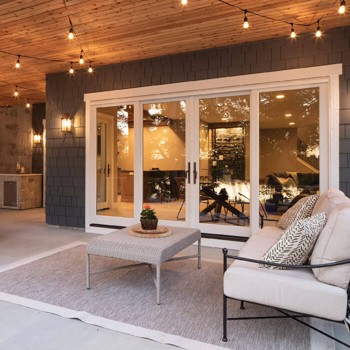 A patio door featuring a couch and table illuminated by string lights in Oklahoma City, OK