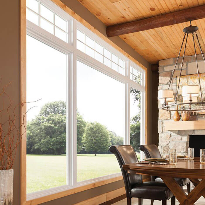 A cozy dining room featuring a stone fireplace and large windows in Oklahoma City, OK